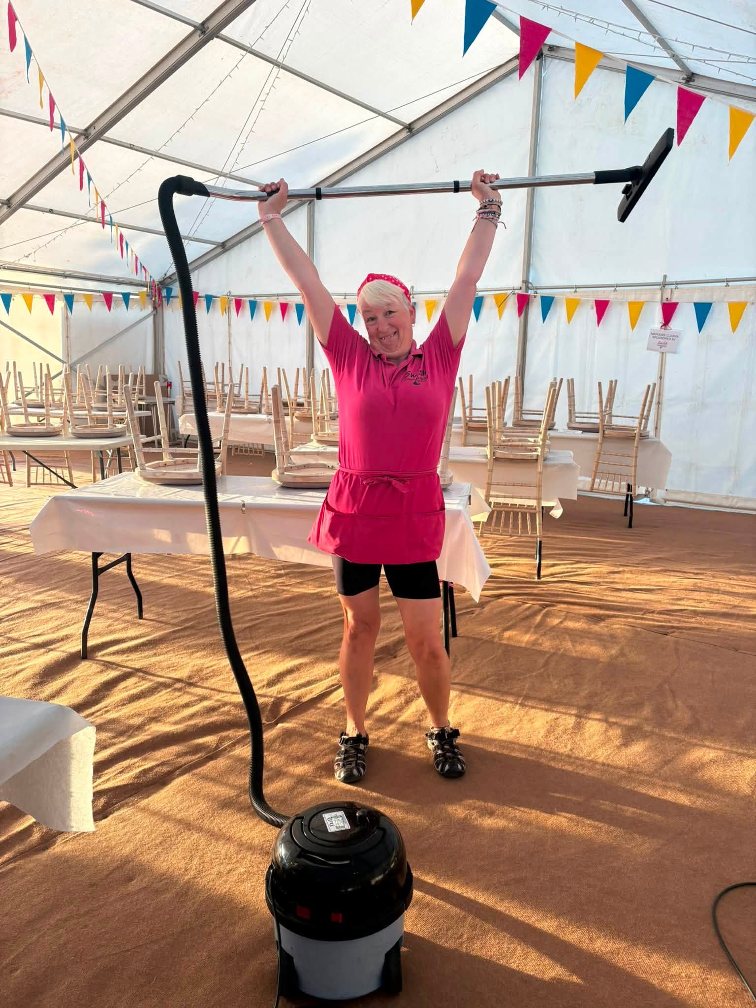 A Swish team member smiling while cleaning a local event marquee